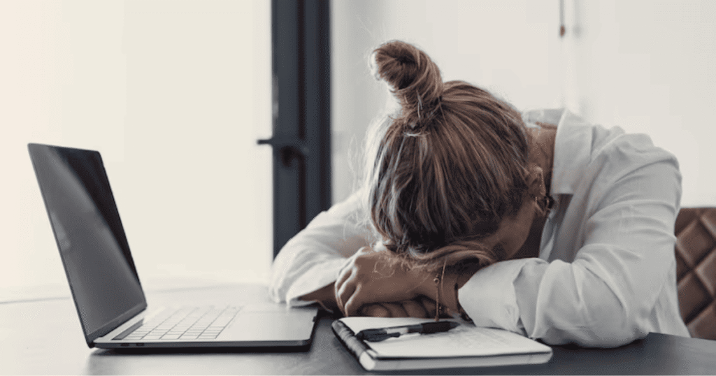 Mujer cansada frente al ordenador trabajando en casa